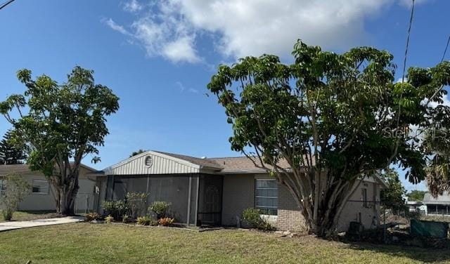 8158 Trionfo Ave, North Port, FL 34287 - view of front of house with a front yard, a sunroom, and concrete driveway
