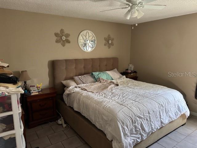 8158 Trionfo Ave, North Port, FL 34287 - tiled bedroom with a textured ceiling and ceiling fan