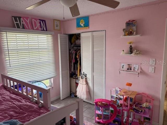 8158 Trionfo Ave, North Port, FL 34287 - tiled bedroom featuring a textured ceiling, a closet, and a ceiling fan