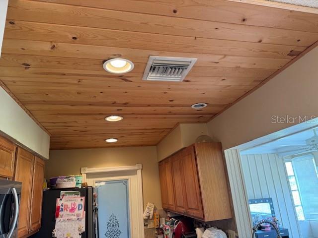 8158 Trionfo Ave, North Port, FL 34287 - detailed view of wood ceiling, freestanding refrigerator, recessed lighting, and stainless steel microwave