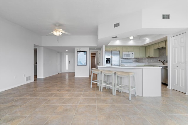 101 N Marion Ct Unit 133, Punta Gorda, FL 33950 - kitchen with stainless steel appliances, green cabinetry, a ceiling fan, light countertops, and a tray ceiling