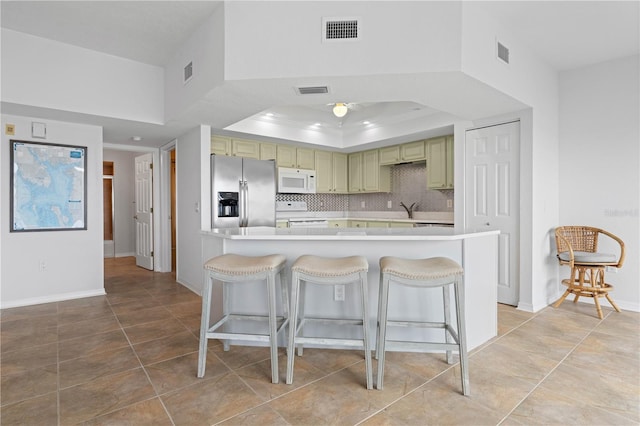 101 N Marion Ct Unit 133, Punta Gorda, FL 33950 - kitchen featuring stainless steel fridge with ice dispenser, white microwave, range with electric stovetop, a kitchen breakfast bar, and light countertops