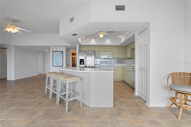 101 N Marion Ct Unit 133, Punta Gorda, FL 33950 - kitchen with appliances with stainless steel finishes, ceiling fan, light tile patterned flooring, green cabinets, and a center island