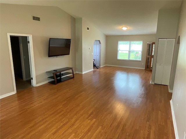 41 Brewster Ln, Palm Coast, FL 32137 - unfurnished living room featuring wood finished floors, lofted ceiling, and baseboards