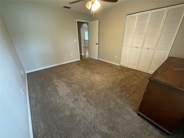 41 Brewster Ln, Palm Coast, FL 32137 - unfurnished bedroom featuring dark carpet, a closet, baseboards, and a ceiling fan