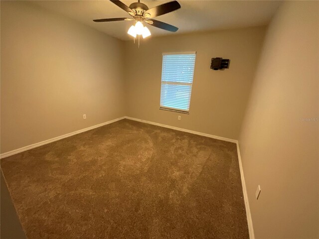 41 Brewster Ln, Palm Coast, FL 32137 - spare room with dark carpet, baseboards, and a ceiling fan