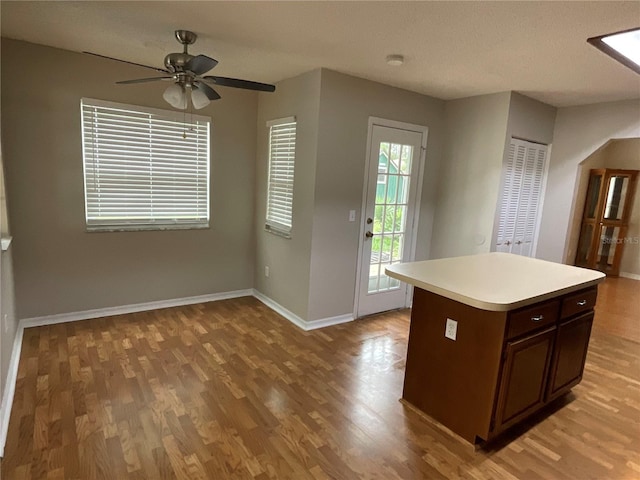 41 Brewster Ln, Palm Coast, FL 32137 - kitchen featuring light wood-style floors, light countertops, baseboards, a ceiling fan, and a kitchen island