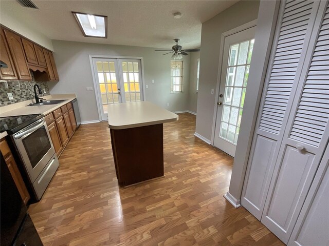 41 Brewster Ln, Palm Coast, FL 32137 - kitchen featuring a sink, stainless steel appliances, light wood-style flooring, light countertops, and tasteful backsplash