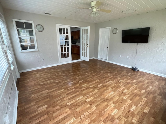 41 Brewster Ln, Palm Coast, FL 32137 - unfurnished living room with ceiling fan, wood finished floors, baseboards, french doors, and a textured wall