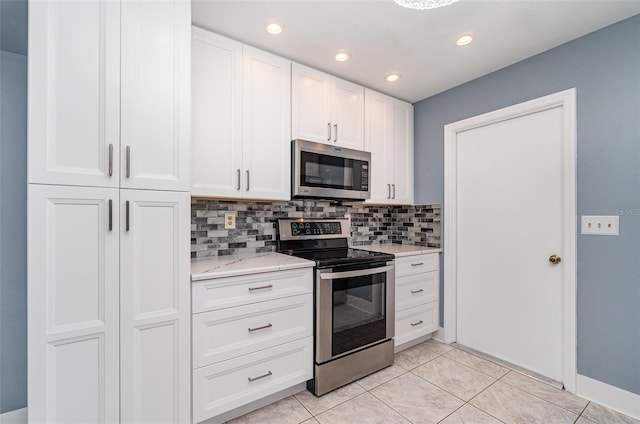 541 Wekiva River Ct Unit 94, Englewood, FL 34223 - kitchen with appliances with stainless steel finishes, tasteful backsplash, white cabinets, recessed lighting, and light stone counters