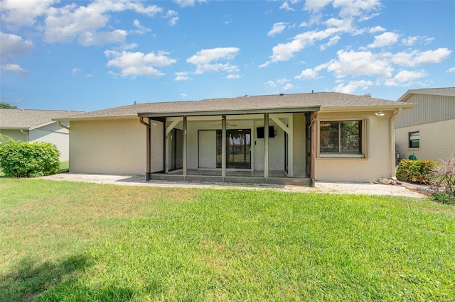 541 Wekiva River Ct Unit 94, Englewood, FL 34223 - back of house featuring a sunroom, stucco siding, and a yard