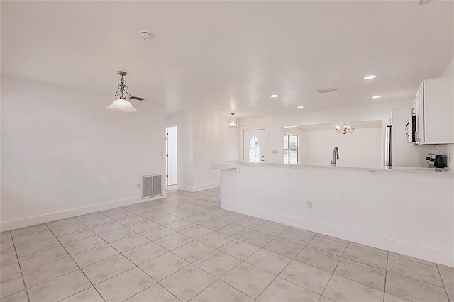 3129 Buttonwood Pl, Punta Gorda, FL 33950 - unfurnished living room featuring light tile patterned flooring, recessed lighting, baseboards, a sink, and a chandelier