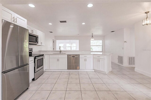 3129 Buttonwood Pl, Punta Gorda, FL 33950 - kitchen featuring appliances with stainless steel finishes, a peninsula, a sink, light countertops, and white cabinets