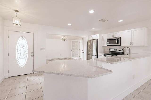 3129 Buttonwood Pl, Punta Gorda, FL 33950 - kitchen featuring stainless steel appliances, light tile patterned floors, a chandelier, light stone countertops, and recessed lighting