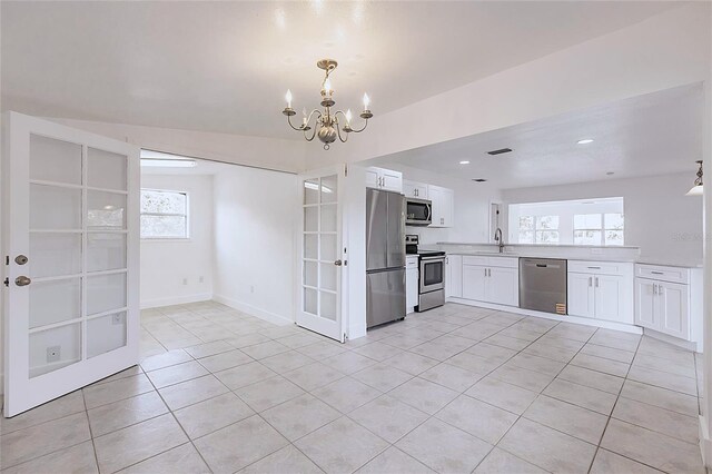 3129 Buttonwood Pl, Punta Gorda, FL 33950 - kitchen with stainless steel appliances, a sink, light tile patterned flooring, a chandelier, and light countertops