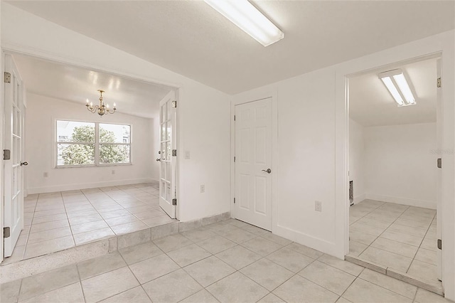 3129 Buttonwood Pl, Punta Gorda, FL 33950 - unfurnished room featuring light tile patterned floors, vaulted ceiling, a chandelier, and baseboards