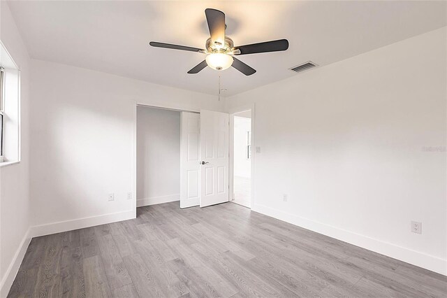 3129 Buttonwood Pl, Punta Gorda, FL 33950 - unfurnished bedroom with wood finished floors, baseboards, a closet, and a ceiling fan