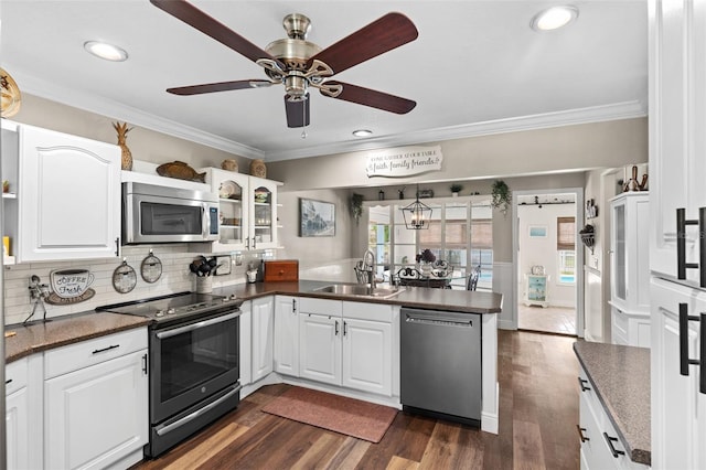 425 Corrientes Cir, Punta Gorda, FL 33983 - kitchen featuring stainless steel appliances, a sink, a peninsula, dark countertops, and ornamental molding