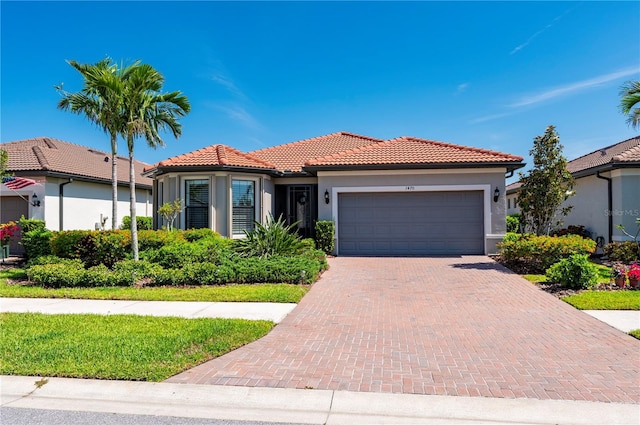 1470 Hyssop Loop, North Port, FL 34289 - mediterranean / spanish-style house with a tile roof, stucco siding, an attached garage, and decorative driveway