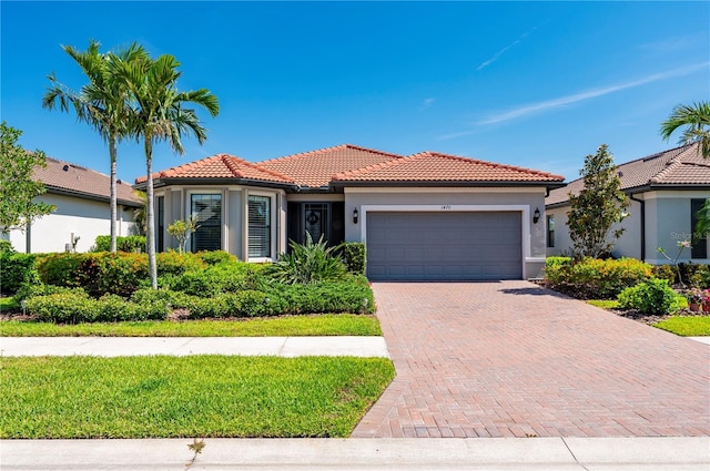 1470 Hyssop Loop, North Port, FL 34289 - view of front of home featuring a garage, stucco siding, a tiled roof, and decorative driveway