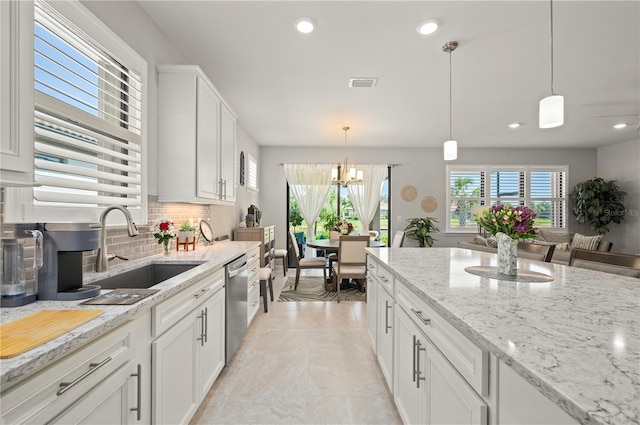 1470 Hyssop Loop, North Port, FL 34289 - kitchen with a sink, dishwasher, decorative backsplash, white cabinets, and a chandelier