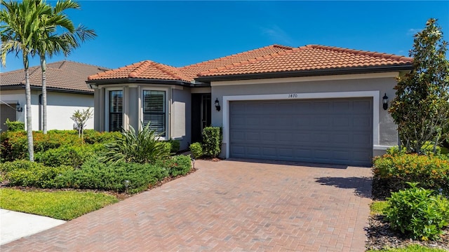 1470 Hyssop Loop, North Port, FL 34289 - view of front of house featuring a tiled roof, a garage, and stucco siding