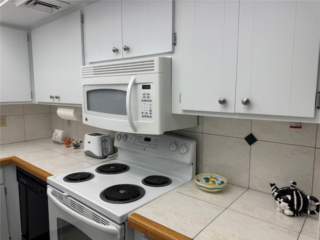 2437 Harbor Blvd Unit 106, Port Charlotte, FL 33952 - kitchen featuring white appliances, tasteful backsplash, and white cabinets