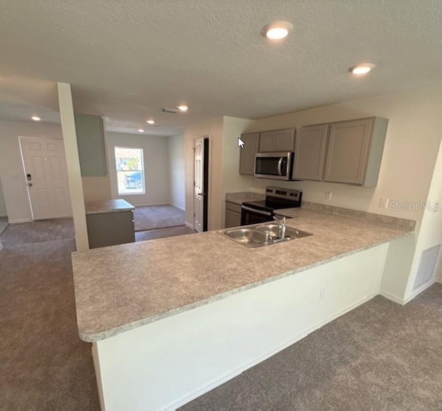 42 Peppercorn Ln, Palm Coast, FL 32164 - kitchen with stainless steel appliances, carpet, a sink, light countertops, and a textured ceiling