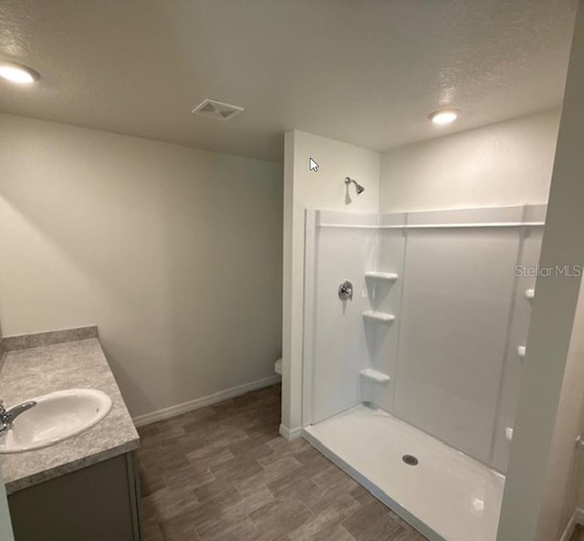 42 Peppercorn Ln, Palm Coast, FL 32164 - bathroom featuring vanity, toilet, a shower, baseboards, and a textured ceiling