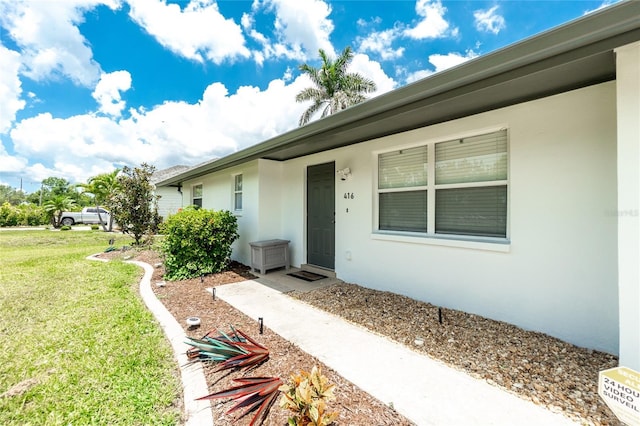 416 Allen St, Punta Gorda, FL 33950 - property entrance with stucco siding and a lawn