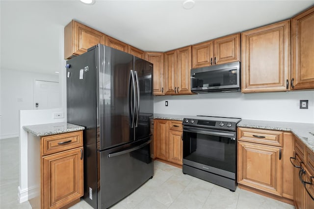 416 Allen St, Punta Gorda, FL 33950 - kitchen with freestanding refrigerator, electric range, brown cabinets, and light stone countertops