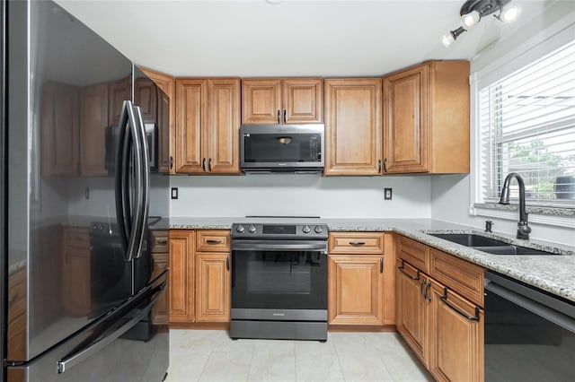 416 Allen St, Punta Gorda, FL 33950 - kitchen with appliances with stainless steel finishes, a sink, light stone countertops, brown cabinetry, and light tile patterned floors