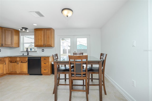 416 Allen St, Punta Gorda, FL 33950 - kitchen featuring dishwasher, brown cabinetry, a sink, and light countertops