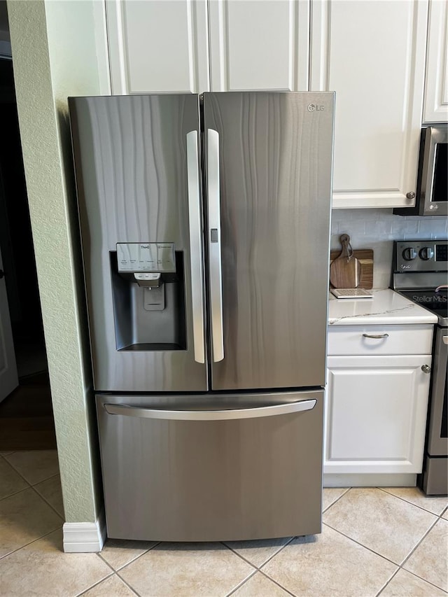 96 Vivante Blvd Unit 9622, Punta Gorda, FL 33950 - kitchen with appliances with stainless steel finishes, white cabinetry, and light tile patterned floors
