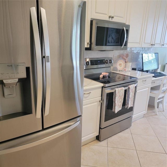 96 Vivante Blvd Unit 9622, Punta Gorda, FL 33950 - kitchen featuring stainless steel appliances, white cabinets, light tile patterned floors, and tasteful backsplash