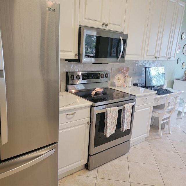 96 Vivante Blvd Unit 9622, Punta Gorda, FL 33950 - kitchen featuring stainless steel appliances, light tile patterned flooring, white cabinets, and tasteful backsplash