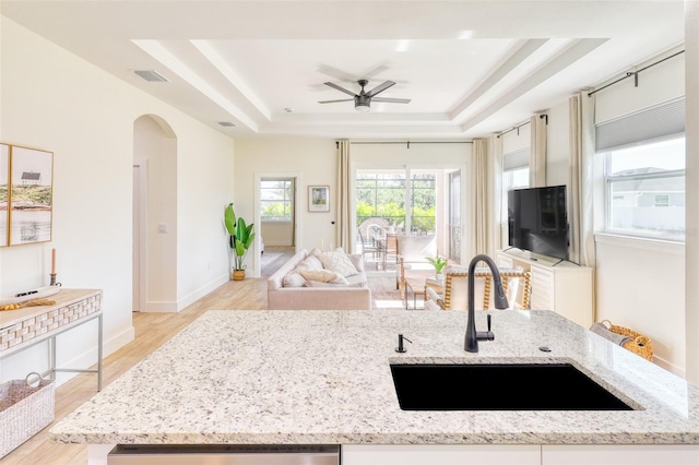 122 Arrow Ln, Rotonda West, FL 33947 - kitchen with a sink, a tray ceiling, open floor plan, a ceiling fan, and arched walkways