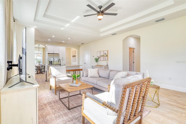 122 Arrow Ln, Rotonda West, FL 33947 - living area with a tray ceiling, arched walkways, a ceiling fan, light wood finished floors, and recessed lighting