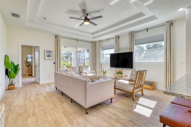 122 Arrow Ln, Rotonda West, FL 33947 - living area with a raised ceiling, healthy amount of natural light, a ceiling fan, and light wood-style floors