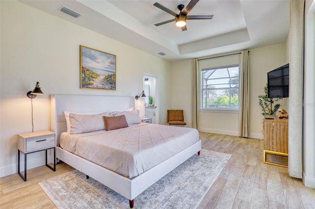 122 Arrow Ln, Rotonda West, FL 33947 - bedroom with a tray ceiling, light wood-type flooring, and baseboards