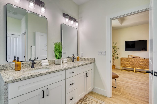 122 Arrow Ln, Rotonda West, FL 33947 - bathroom featuring double vanity, wood finished floors, and baseboards