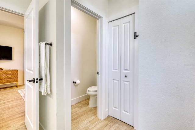 122 Arrow Ln, Rotonda West, FL 33947 - bathroom with a closet, wood finished floors, toilet, and baseboards
