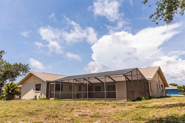 238 Mark Twain Ln, Rotonda West, FL 33947 - rear view of house with a lawn, stucco siding, and a lanai