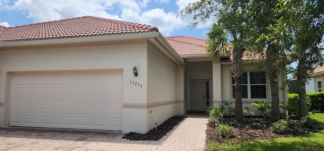 13256 Creekside Ln, Port Charlotte, FL 33953 - view of front of home with a tiled roof, stucco siding, an attached garage, and driveway