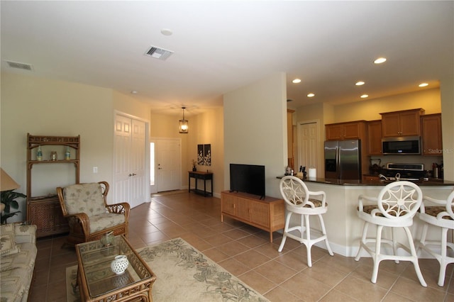 13256 Creekside Ln, Port Charlotte, FL 33953 - kitchen with stainless steel appliances, light tile patterned floors, a breakfast bar area, recessed lighting, and dark countertops