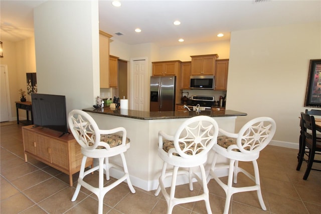 13256 Creekside Ln, Port Charlotte, FL 33953 - kitchen with appliances with stainless steel finishes, tile patterned floors, a kitchen bar, recessed lighting, and a peninsula