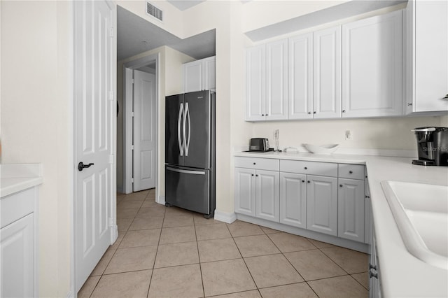 99 Vivante Blvd Unit 303, Punta Gorda, FL 33950 - kitchen with freestanding refrigerator, light tile patterned flooring, white cabinetry, light countertops, and a sink