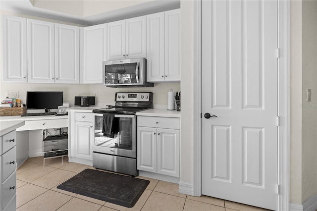 99 Vivante Blvd Unit 303, Punta Gorda, FL 33950 - kitchen with stainless steel appliances, white cabinetry, light countertops, and light tile patterned floors