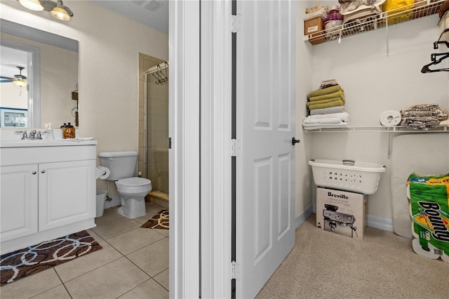 99 Vivante Blvd Unit 303, Punta Gorda, FL 33950 - bathroom with a stall shower, vanity, tile patterned floors, toilet, and ceiling fan
