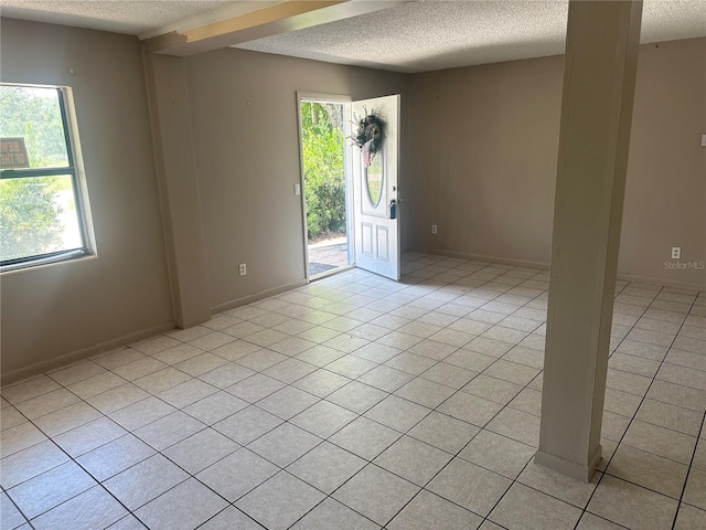 708 N Johnson Ave, Arcadia, FL 34266 - spare room with a textured ceiling, light tile patterned floors, and baseboards